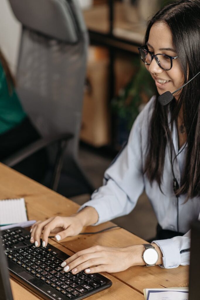 Woman in White Long Sleeve Shirt Using Computer